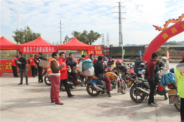 圖為藤縣總工會(huì)在省道304線藤縣陶瓷工業(yè)園區(qū)商業(yè)街小廣場(chǎng)設(shè)立藤縣總工會(huì)為農(nóng)民工平安返鄉(xiāng)“暖流行動(dòng)”服務(wù)站，積極為騎摩托車